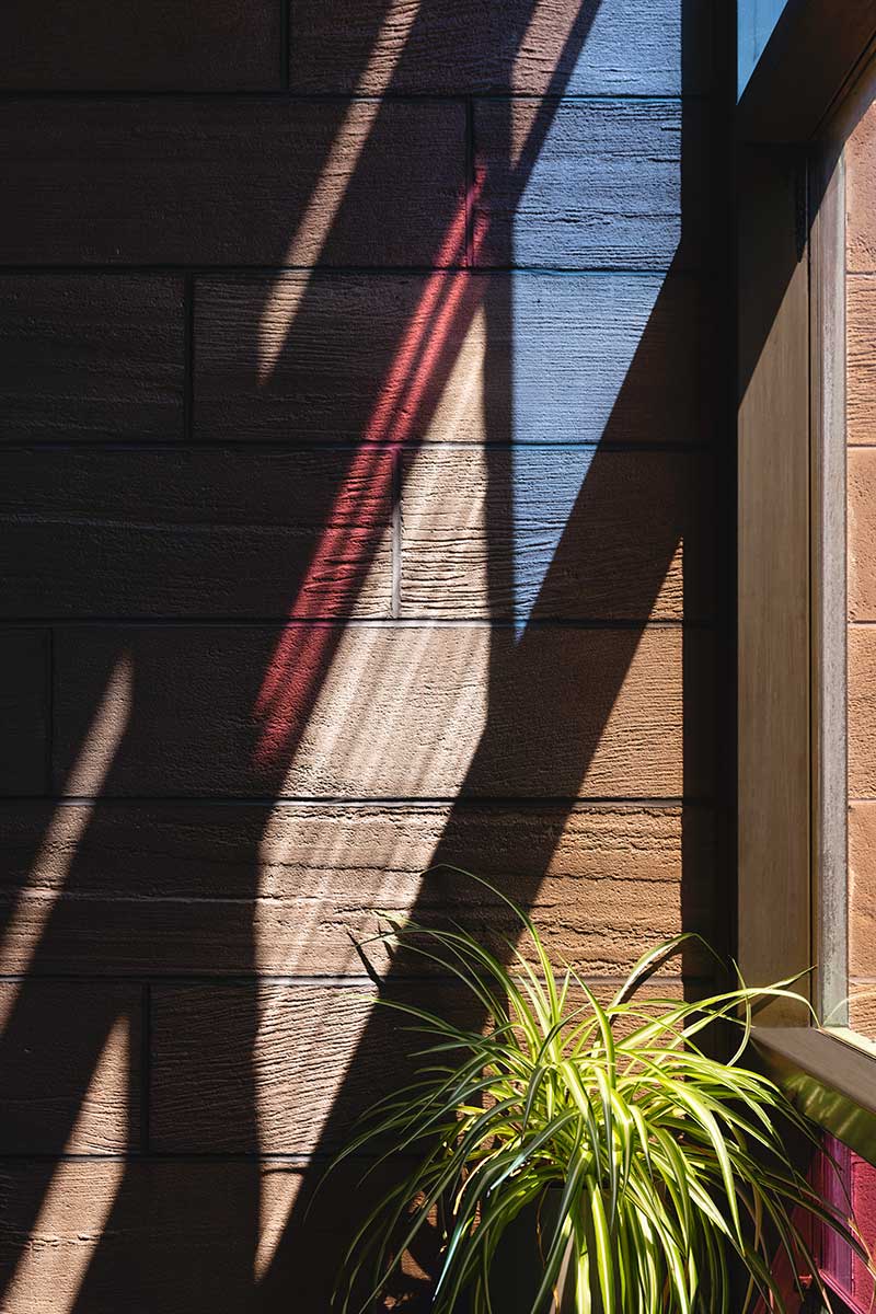 red and blue stained glass windows make a colorful shadow on a wall inside Christ Episcopal Church in Reading, PA.