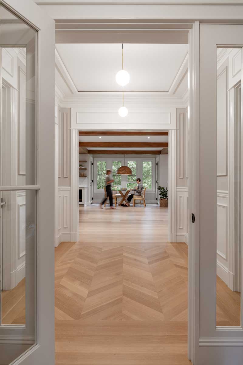 Two women, one sitting and one standing, in a dining area of a renovated historic home featuring Marvin Ultimate Double Hung G2 windows.