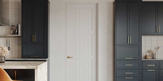 A modern farmhouse kitchen with a white TruStile door, navy cabinetry and white marble countertops.