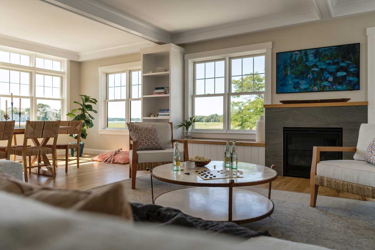 A living room with a round coffee table topped with a game, popcorn and glass bottles of water.