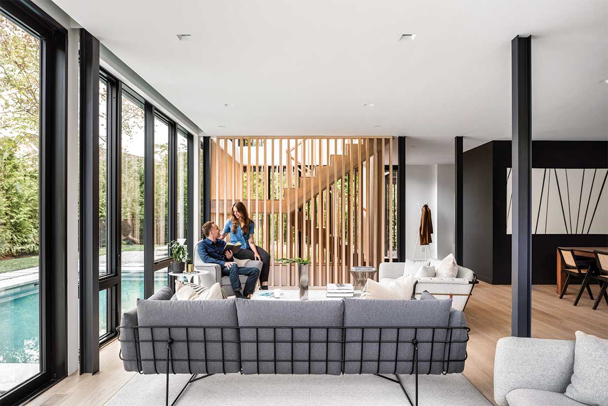 Two people sitting in a modern living room in Sag Harbor, New York,  featuring Marvin Modern windows and doors.