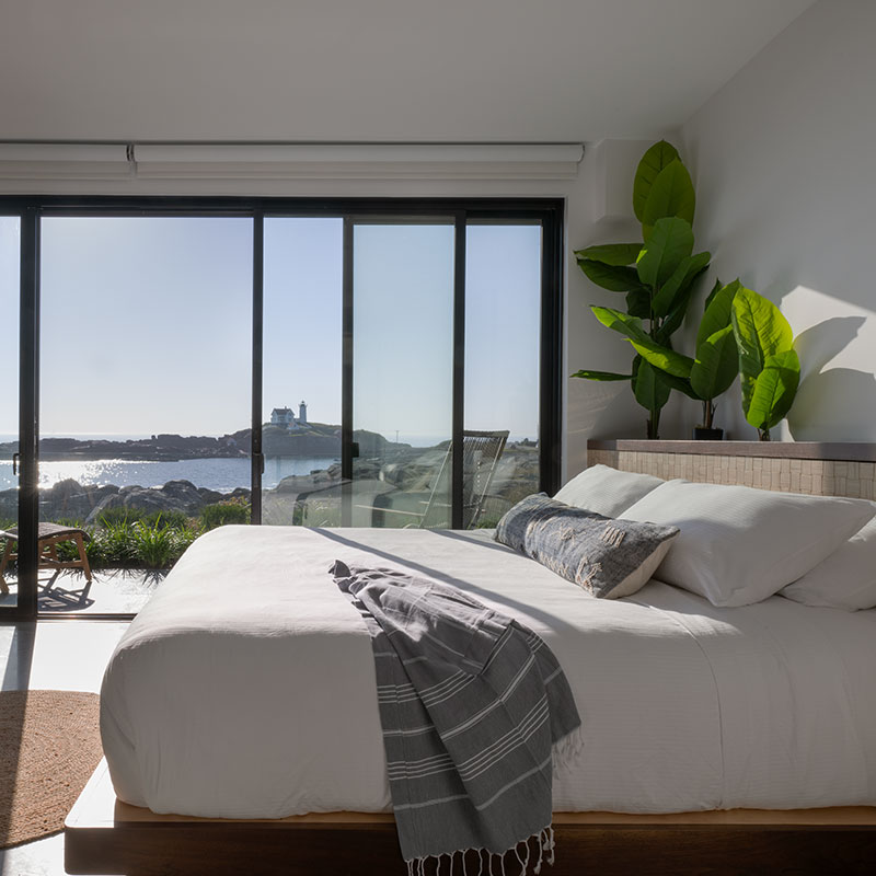 A view of the Nubble Lighthouse from inside a Viewpoint Hotel private guest suite through a Marvin Elevate Sliding door.