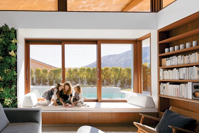 Woman and two children on a bay window seat reading.